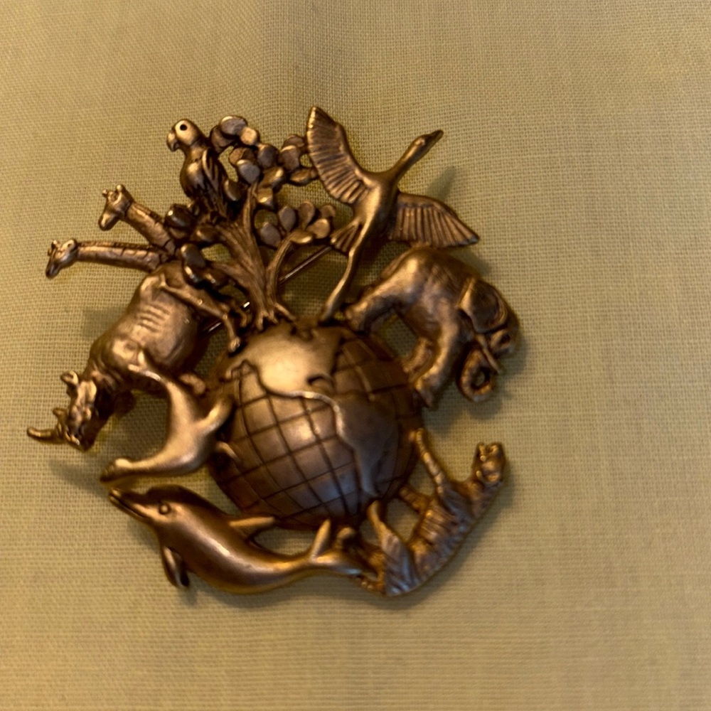 Vintage heavy medal pin  with 9 animals around a globe of the Americas.   $ 29
